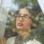 Woman in glasses staring out a window