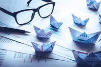 A Pair of glasses resting on a pile of papers